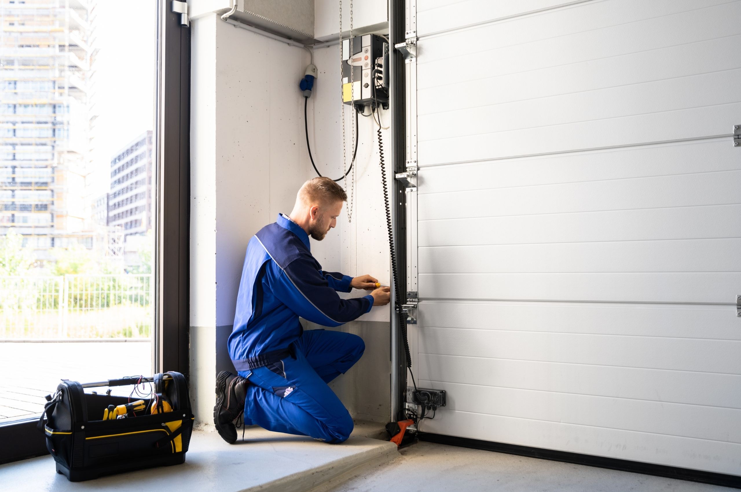 homme qui fait l'installation de portes de garage